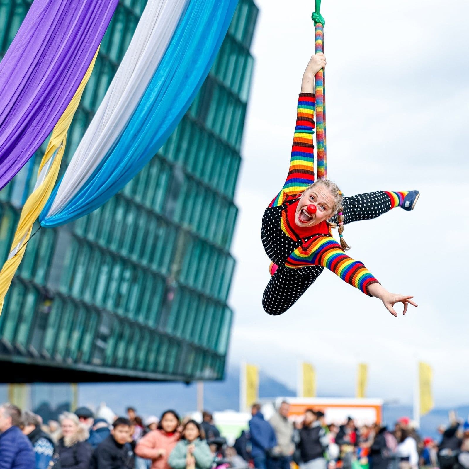 a clown is flying through the air on an aerial hoop .