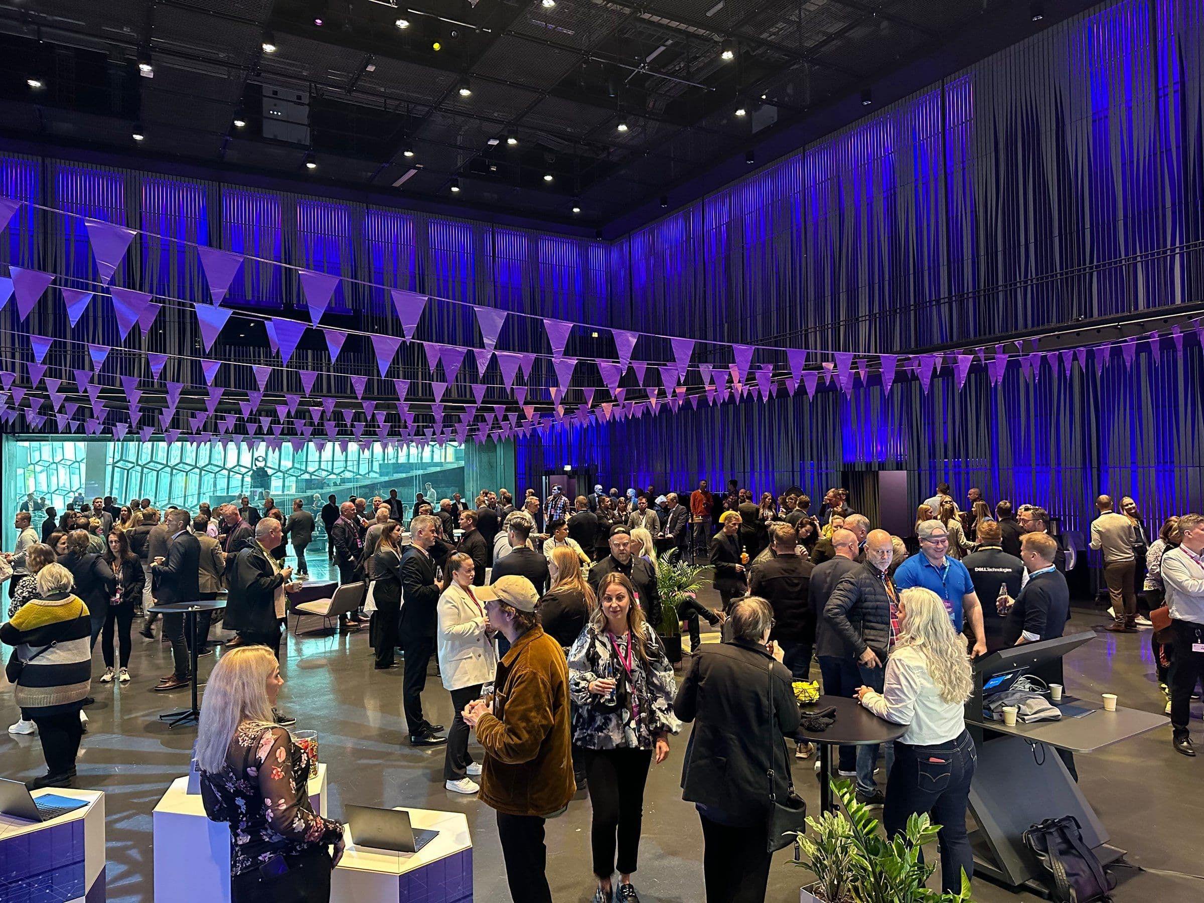 a large group of people are standing in a large room .