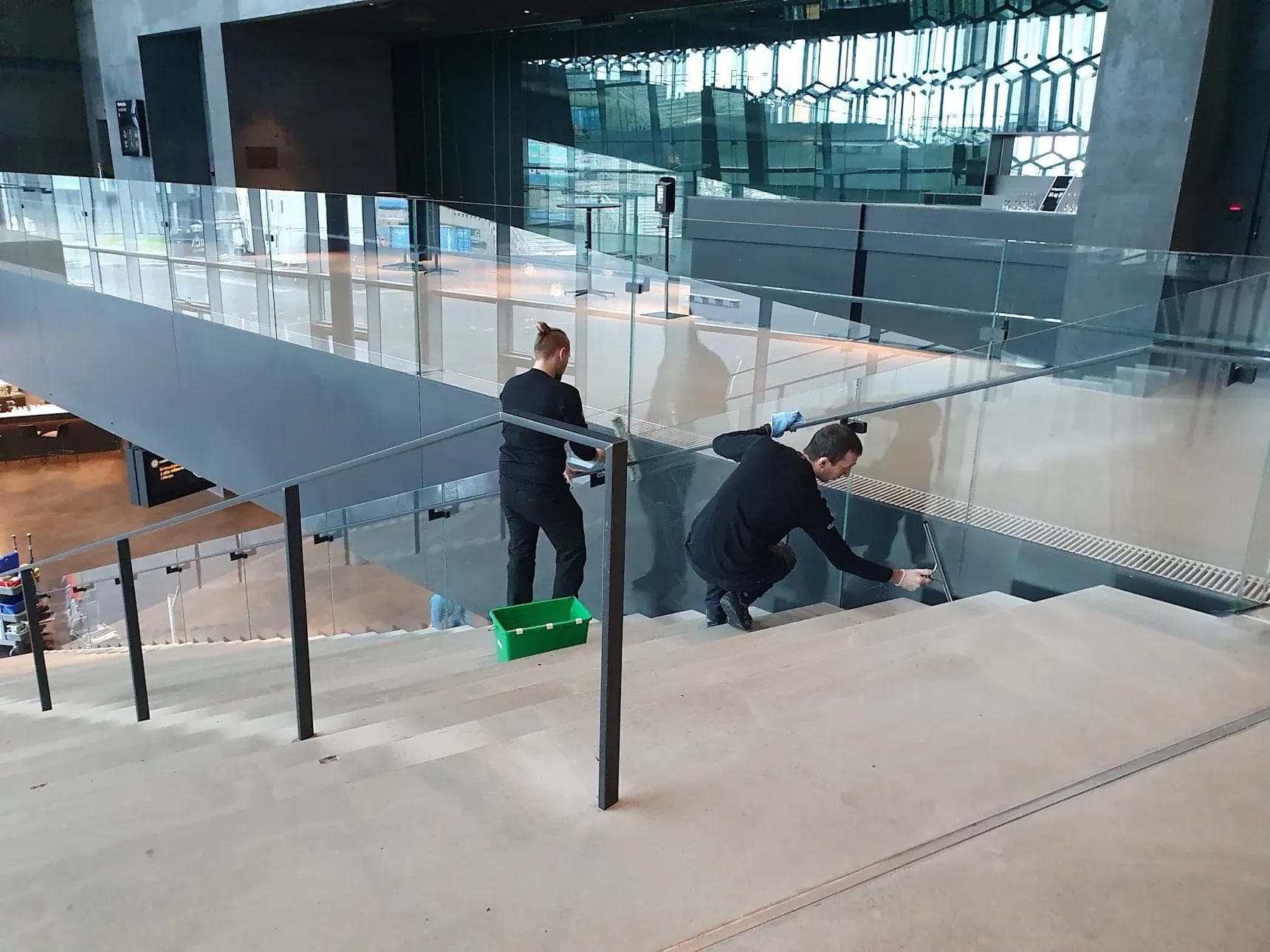 a man and a woman are cleaning the stairs of a building .